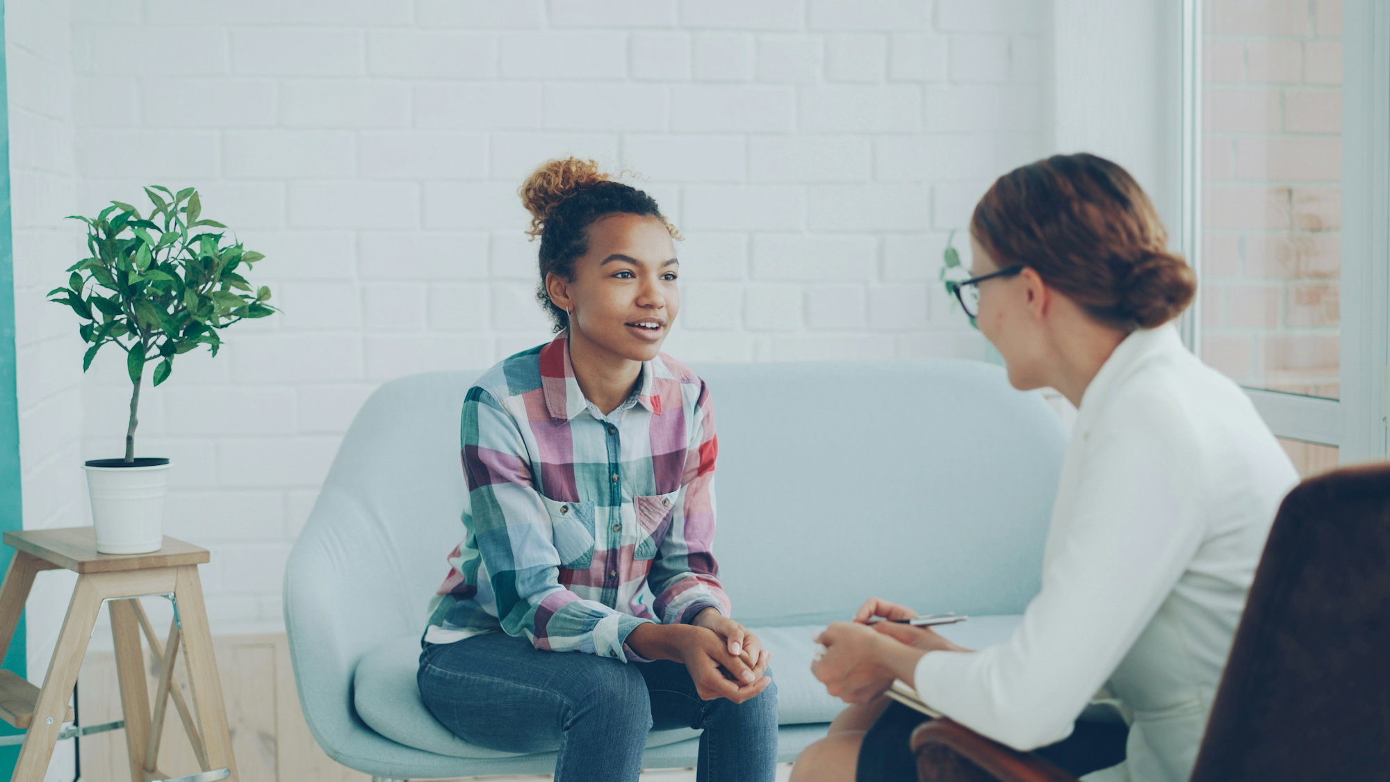 two-women-talking-in-a-modern-office-setting-.jpg Two women talking in a modern office setting.